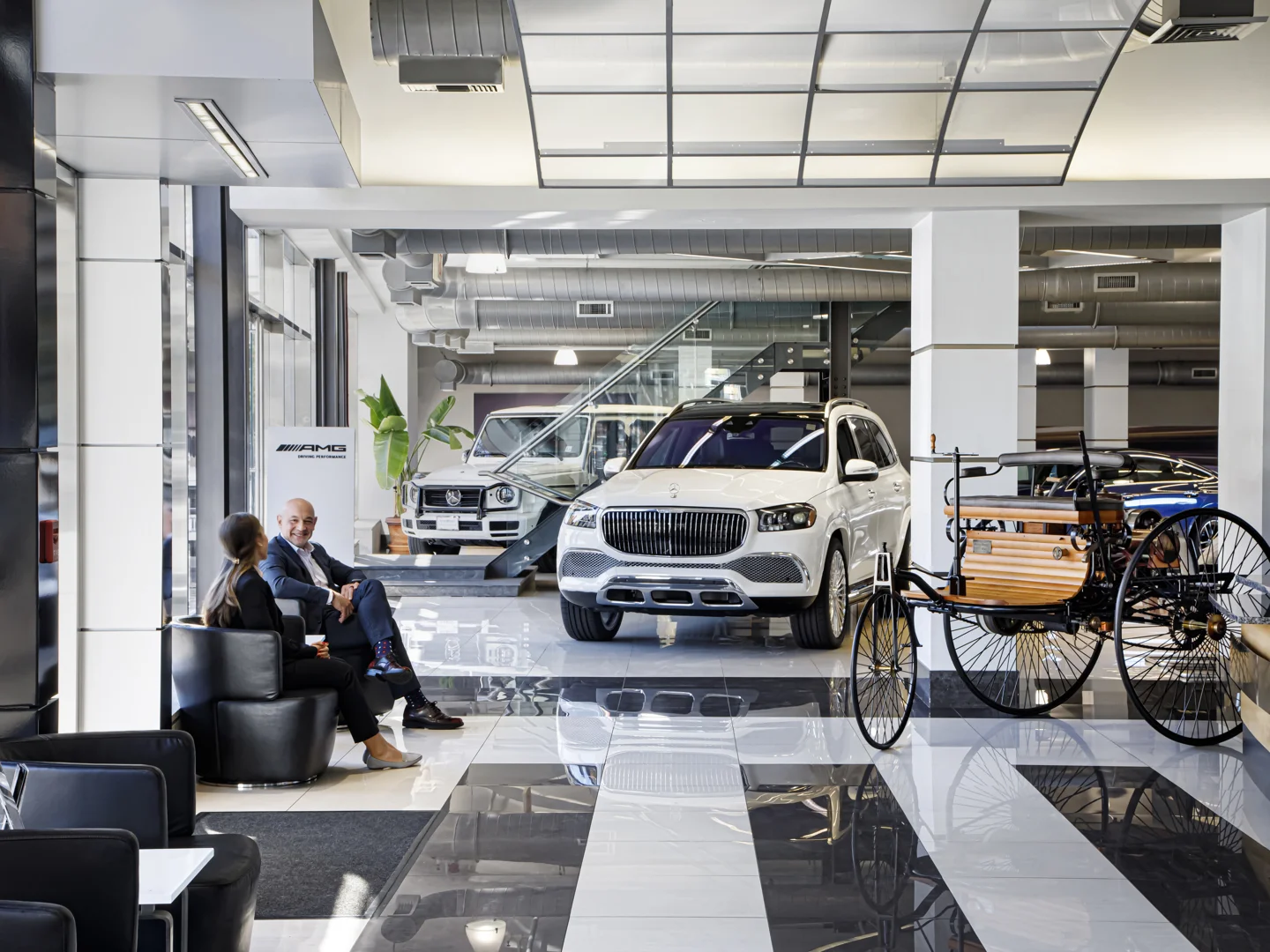 Sales consultant speaking to a customer in a luxury showroom - stress-free, no-pressure car buying, reputable