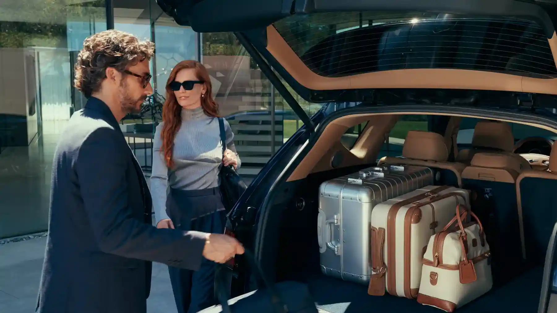 A family safely loading luggage into a luxury SUV - Mercedes-Benz or Genesis A family safely loading luggage into a luxury SUV - Mercedes-Benz or Genesis