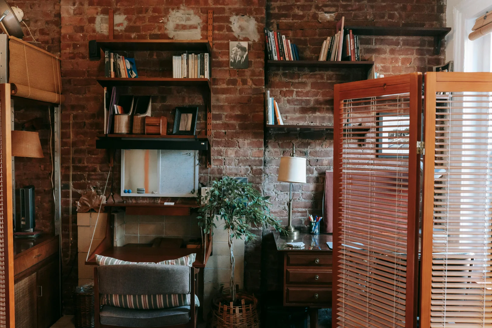a researcher in a well-lit furnished apartment with bookshelves and a desk - post-doc researcher apartments for 6-12 months; photo by Charlotte May 