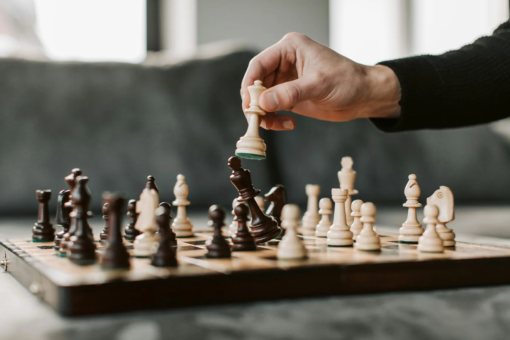 person's hand and a chess board - The Link Between High Performance and Addiction Risk person's hand and a chess board - The Link Between High Performance and Addiction Risk