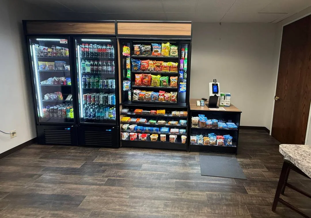 A variety of modern vending machines lined up in a bright office breakroom - Fort Worth vending services