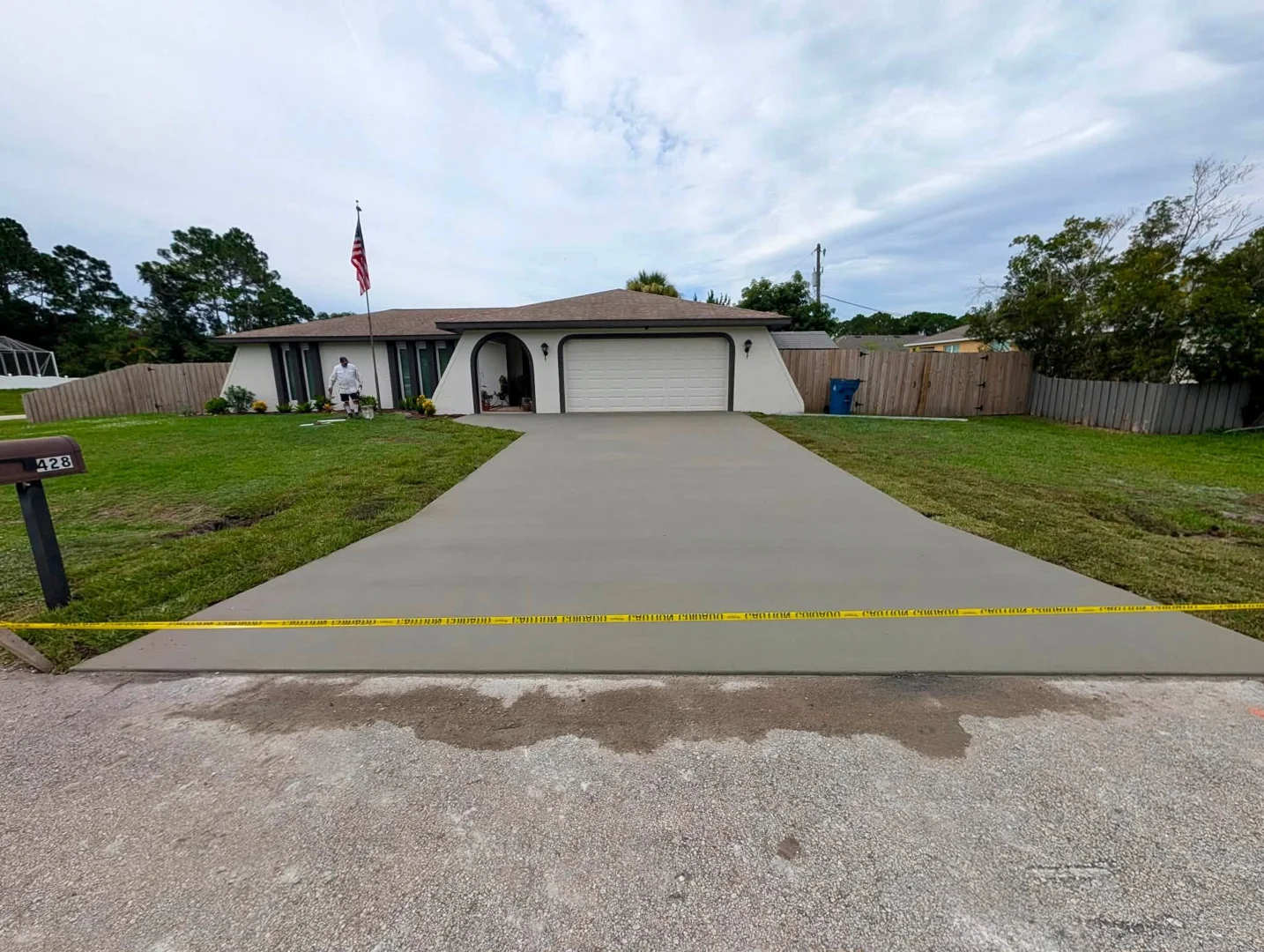 Finished residential concrete driveway with caution tape across the entrance