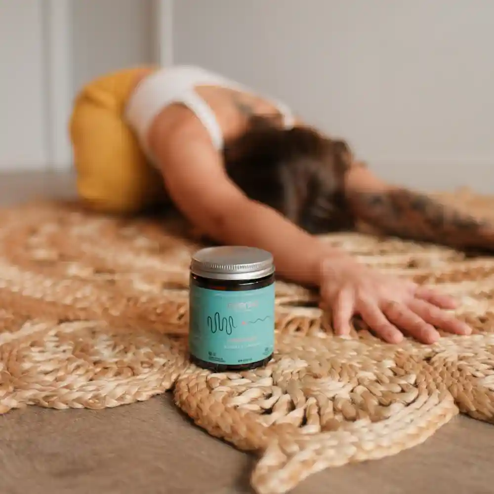 Maitake mushroom extract capsules placed next to a person practicing yoga, perfect for content regarding maitake mushroom dosage.