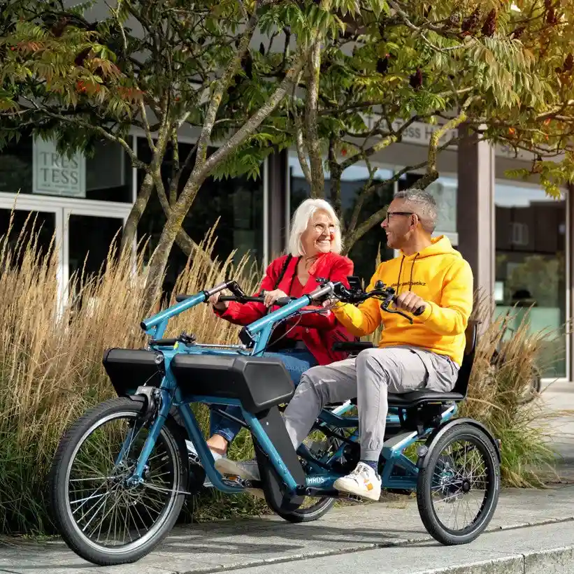 Senior couple riding adaptive trike at sunset - adaptive trike