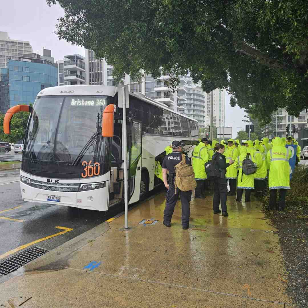 White coach buses at a bus stop, ready for corporate event transport.