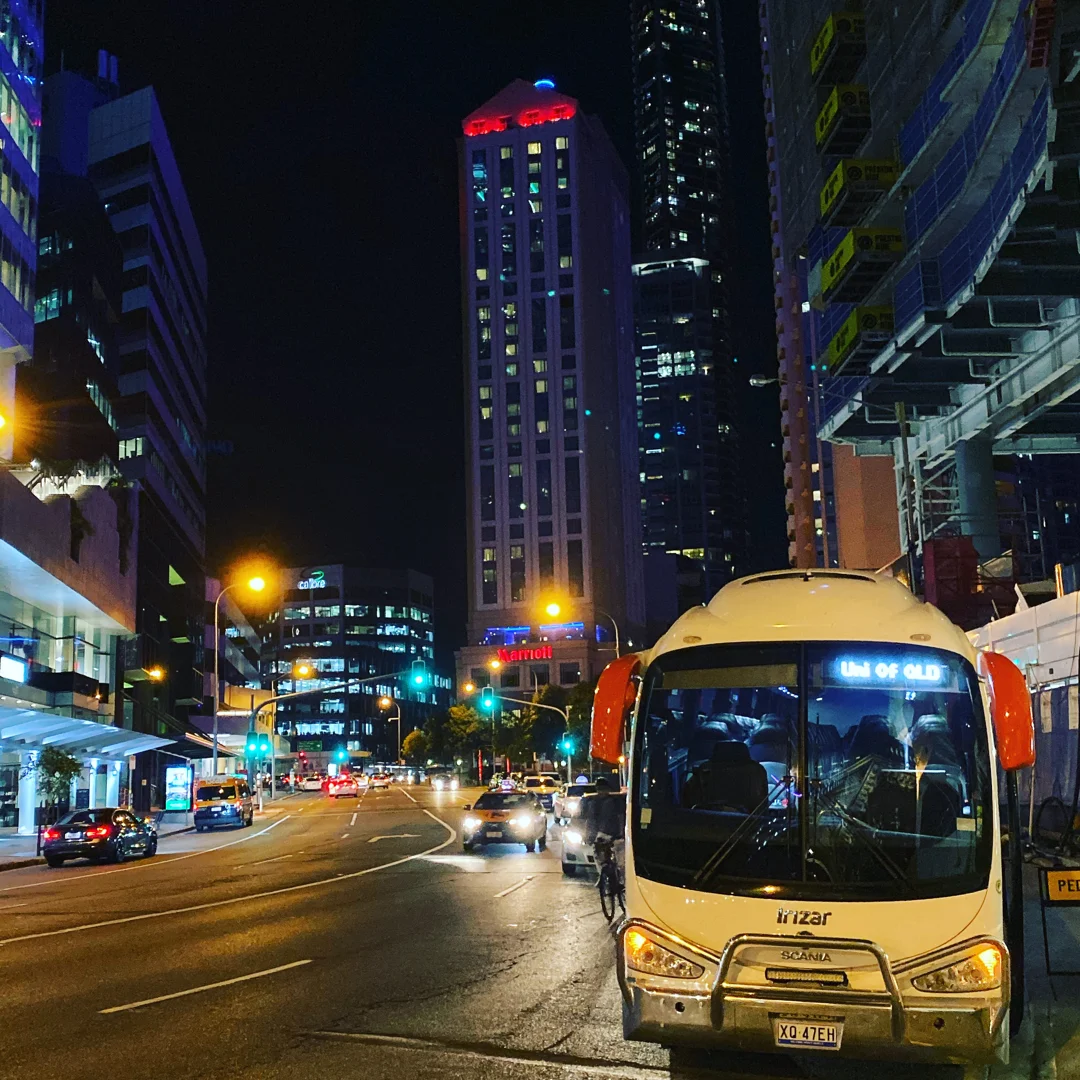 Corporate coach arriving at a Brisbane event venue for group transport.