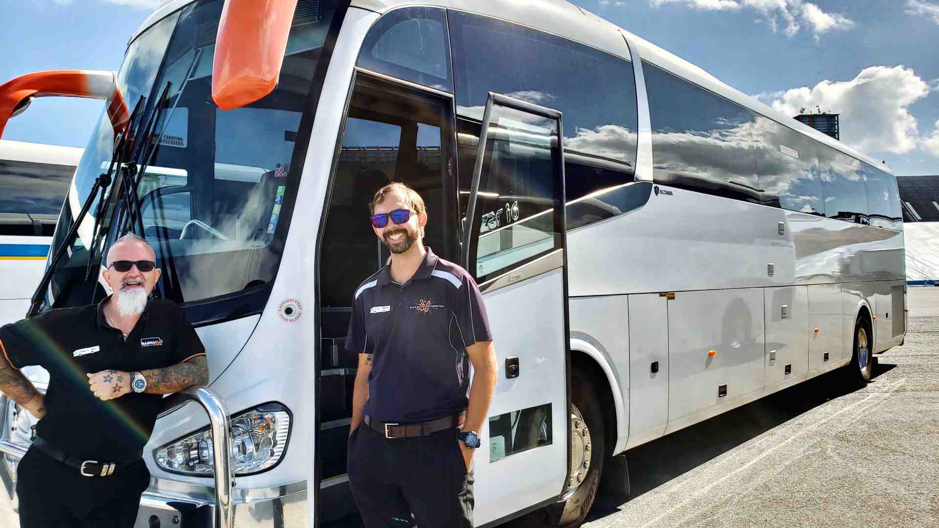 Friendly, professional driver welcoming delegates onto a luxury coach - bus hire for conference delegates in Logan
