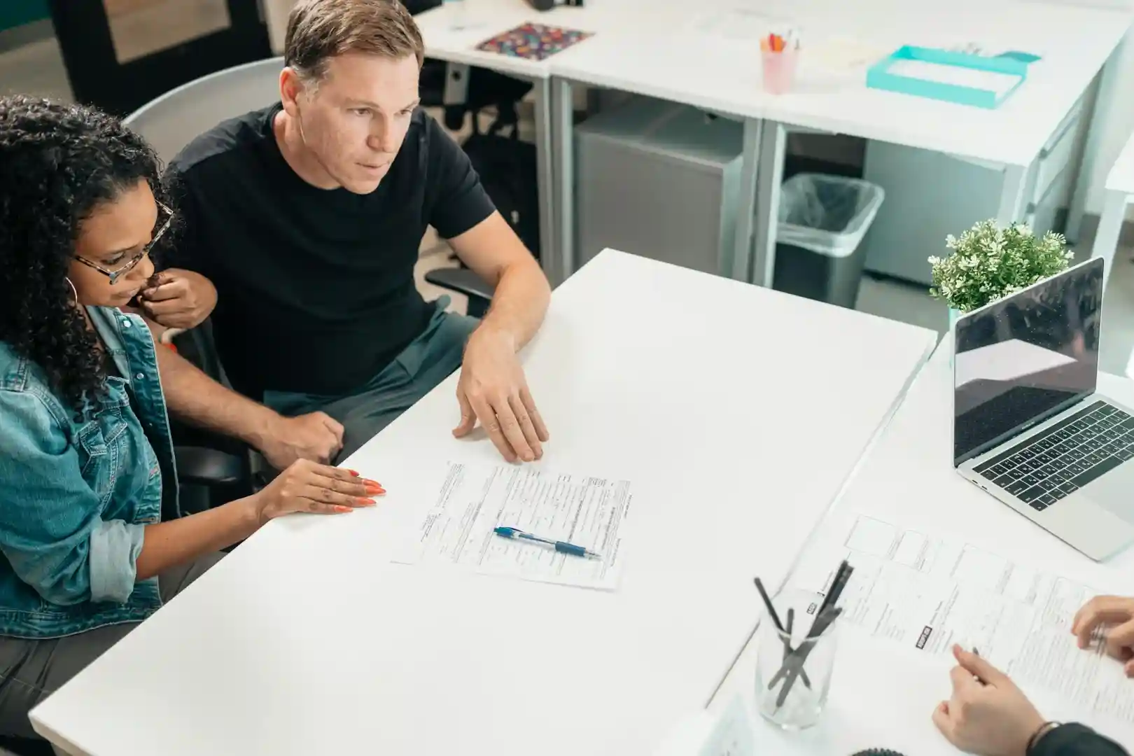 group of people with documents on table - Owner Financing Homes 