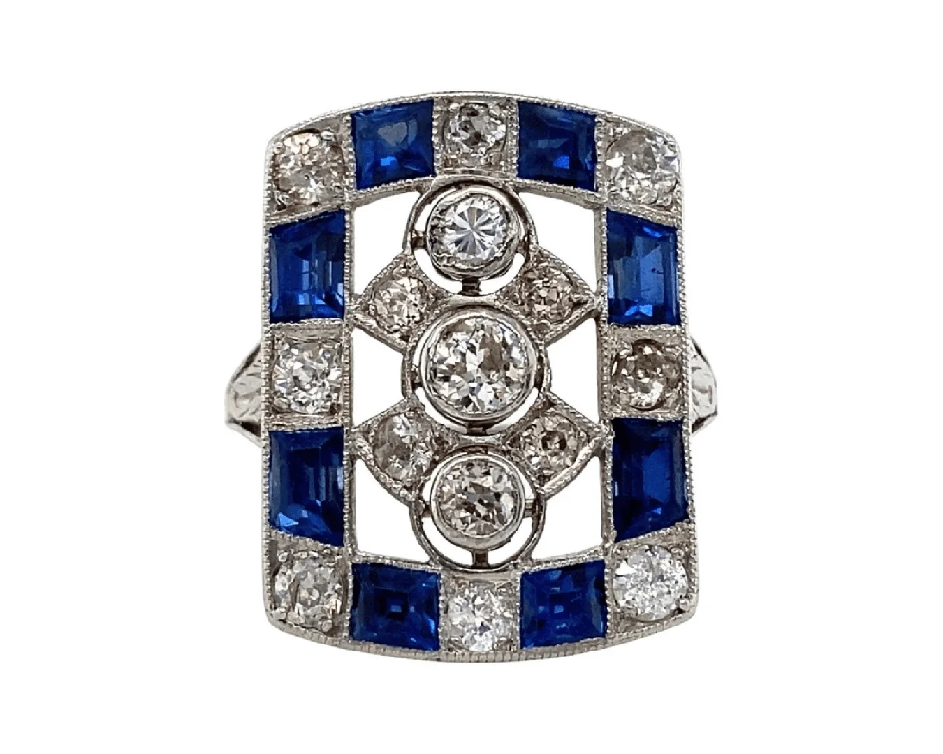 An antique Art Deco diamond and blue sapphire plaque ring on an isolated white background.