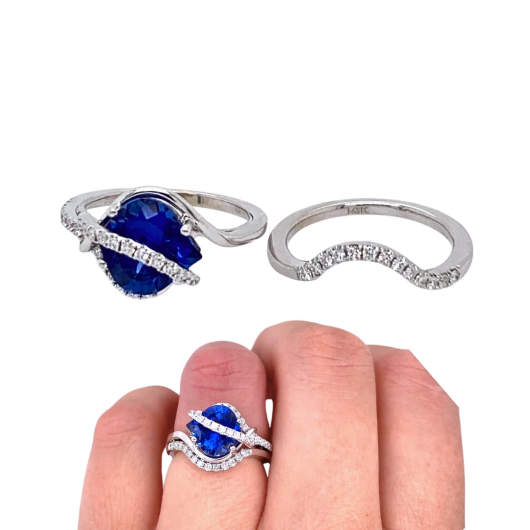 A bridal ring set with a blue sapphire and diamond bypass engagement ring, and a contoured diamond wedding band.