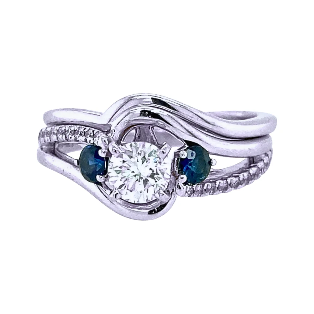 An intricate diamond and blue sapphire bypass engagement with a minimalist polished white gold wedding band.
