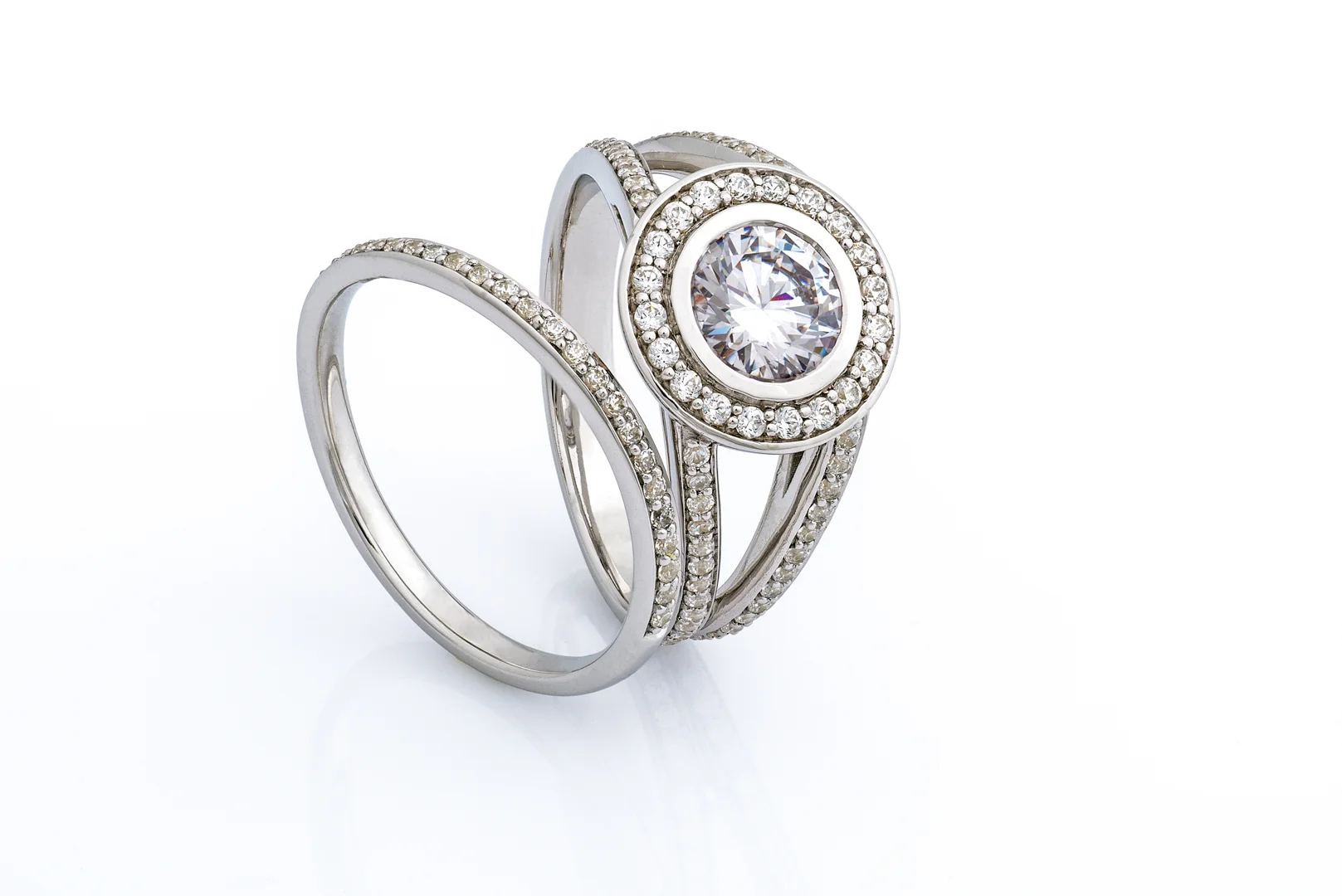 A diamond bridal ring set with a halo and split shank engagement ring, and a classic diamond wedding band.