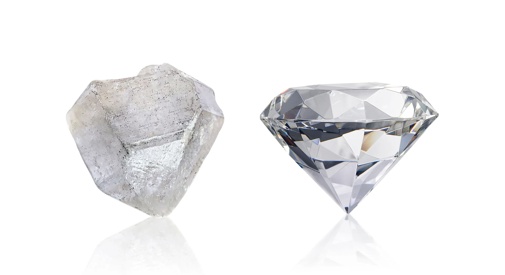 A raw mined diamond and a polished and faceted mined diamond next to each other on a reflective isolated white background
