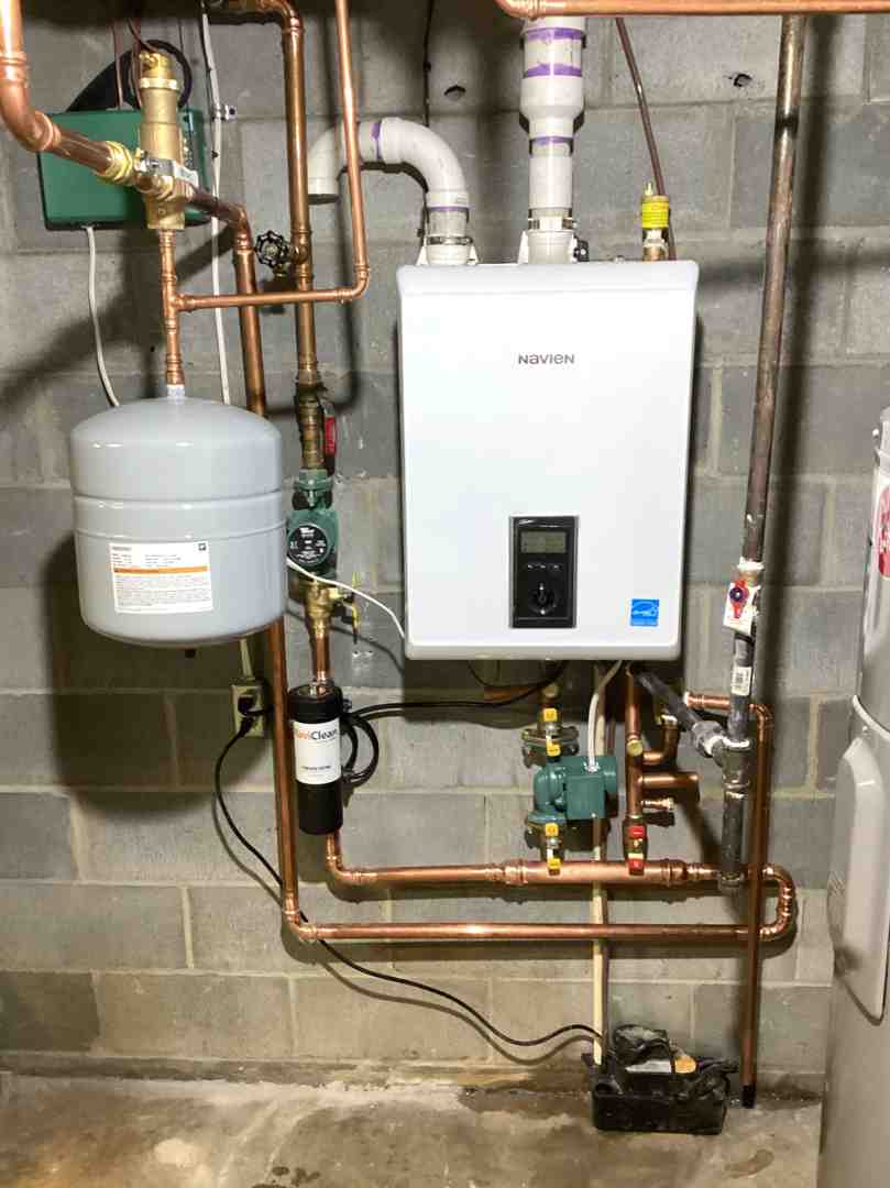 plumber inspecting a modern tankless water heater - plumbing contractor frederick md