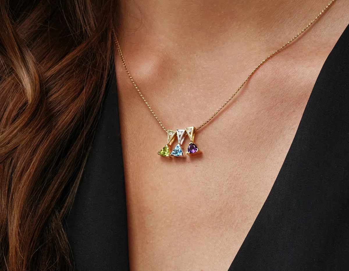 Birthstone pendants layered on gold necklace. By John Atencio. Birthstone pendants layered on gold necklace. By John Atencio.