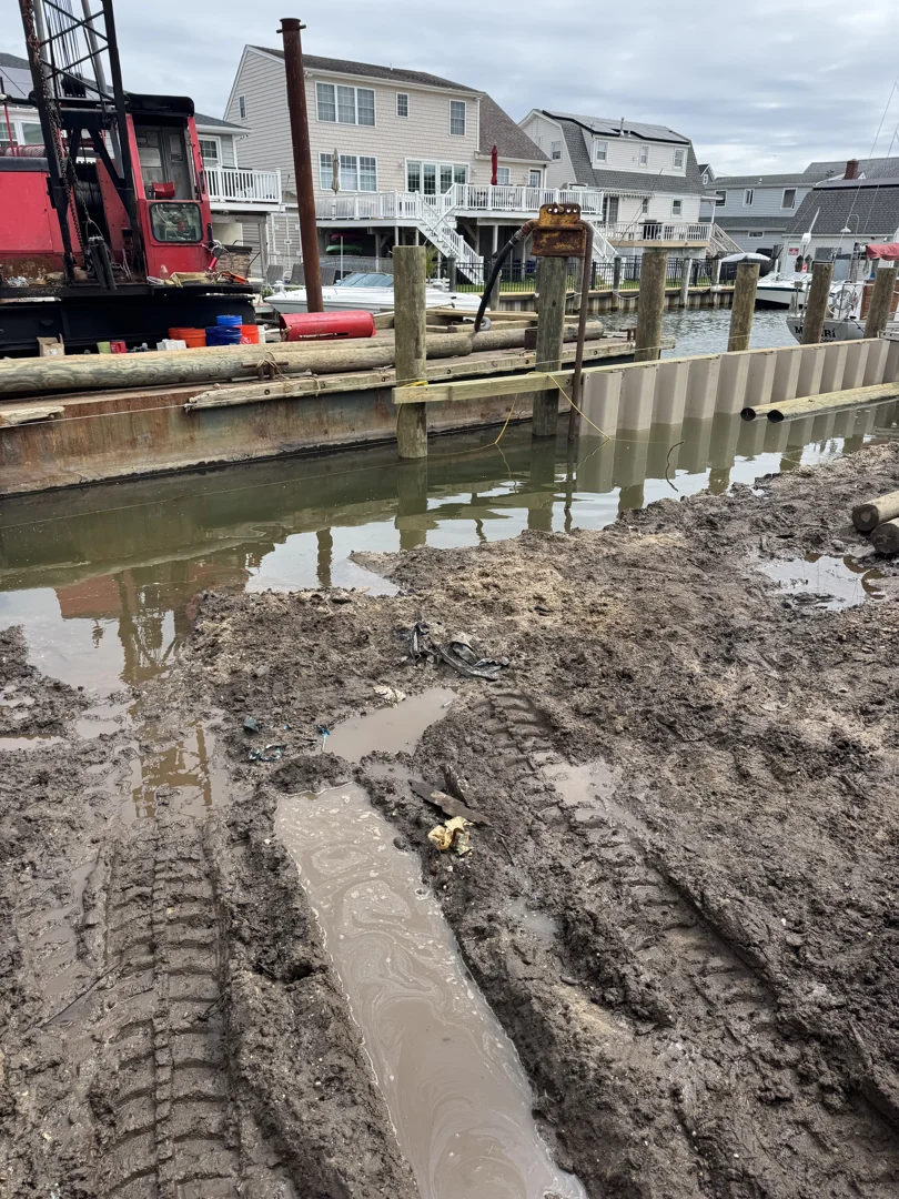 Marine construction crew installing heavy-duty pre-cast concrete panels for a new shoreline barrier