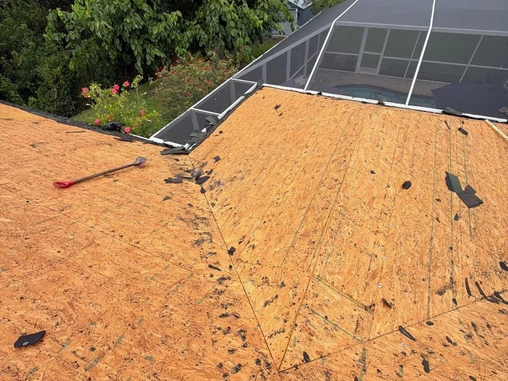 user-inserted Damaged residential roof showing water-damaged decking and torn underlayment from delayed maintenance.