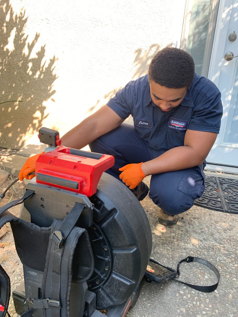 A professional plumber using a video camera inspection tool in a drain. - plumbing service newbury park ca