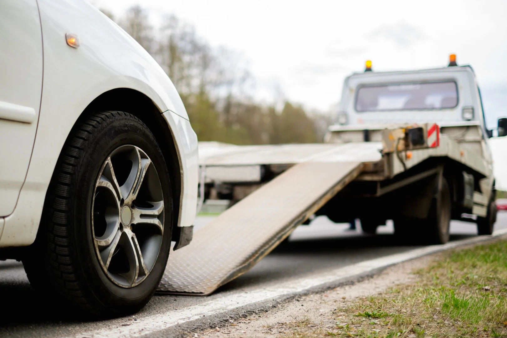Roadside assistance technician helping a Nissan driver beside a safely parked SUV