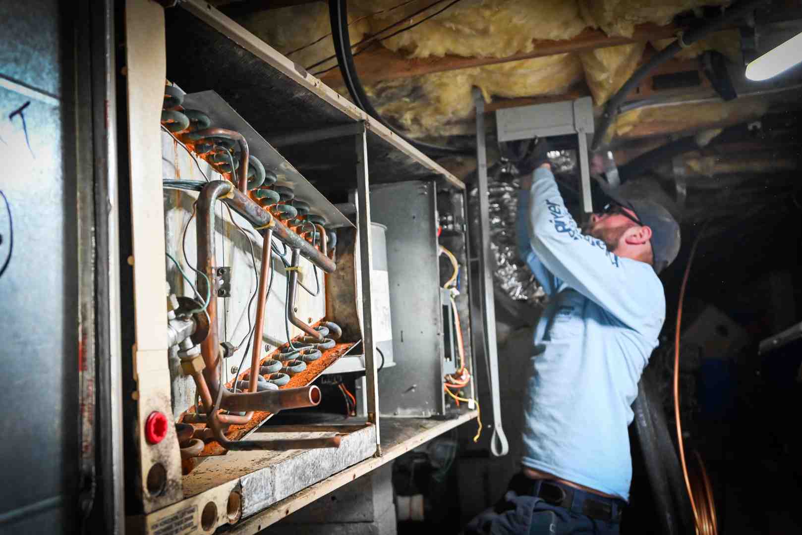 technician inspecting an older outdoor heat pump unit - best heat pump company in bon air, va