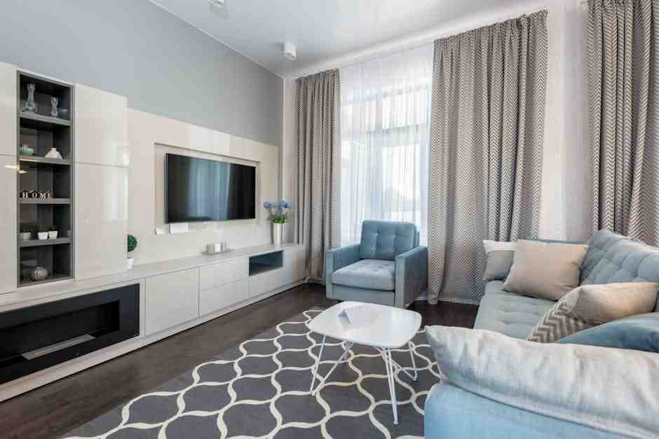 Modern living room with neutral decor, soft blue seating, large windows, and clean finishes, staged to feel bright, open, and move-in ready.
