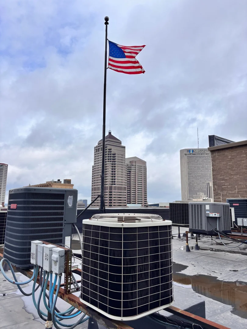 Ohio Heating professional HVAC technician wearing work gloves inspecting an outdoor AC unit