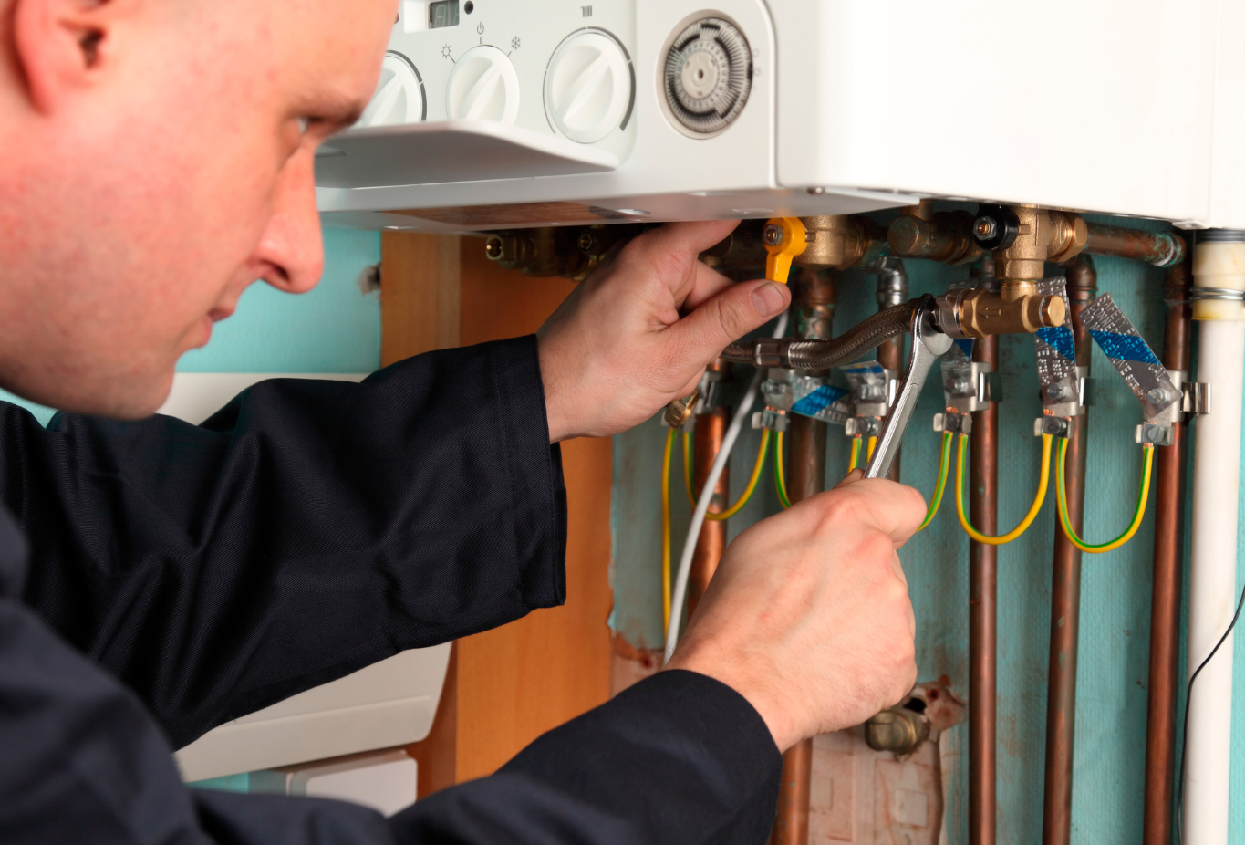 A close-up image of a technician inspecting the internal components of a boiler, with tools laid out nearby - Boiler repair prices