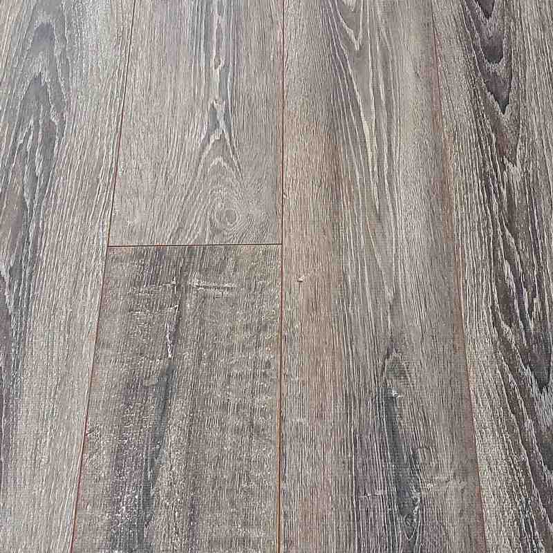close-up shot showing the texture and layers of a high-quality laminate plank, highlighting its wear layer and core - discount flooring BC