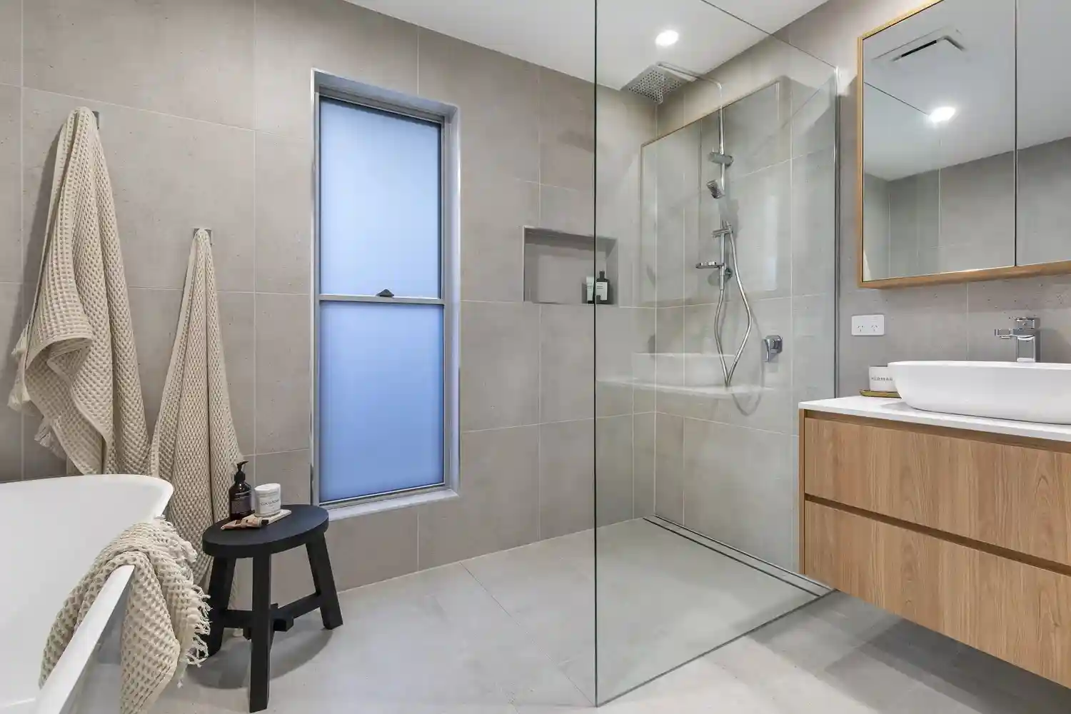 Master ensuite with frameless glass shower and modern vanity