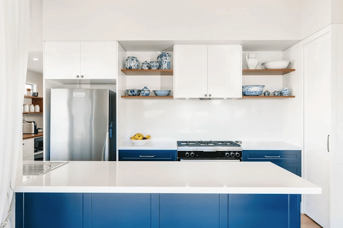 Modern kitchen with a clean, minimalist design featuring white upper cabinets and deep blue lower cabinets.