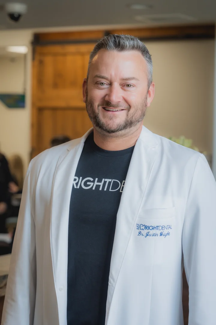 Dr. Justin Wright, DDS, in a white coat at Just Wright Dental and Implant Center, Corsicana, Texas, discussing broken implant screw removal