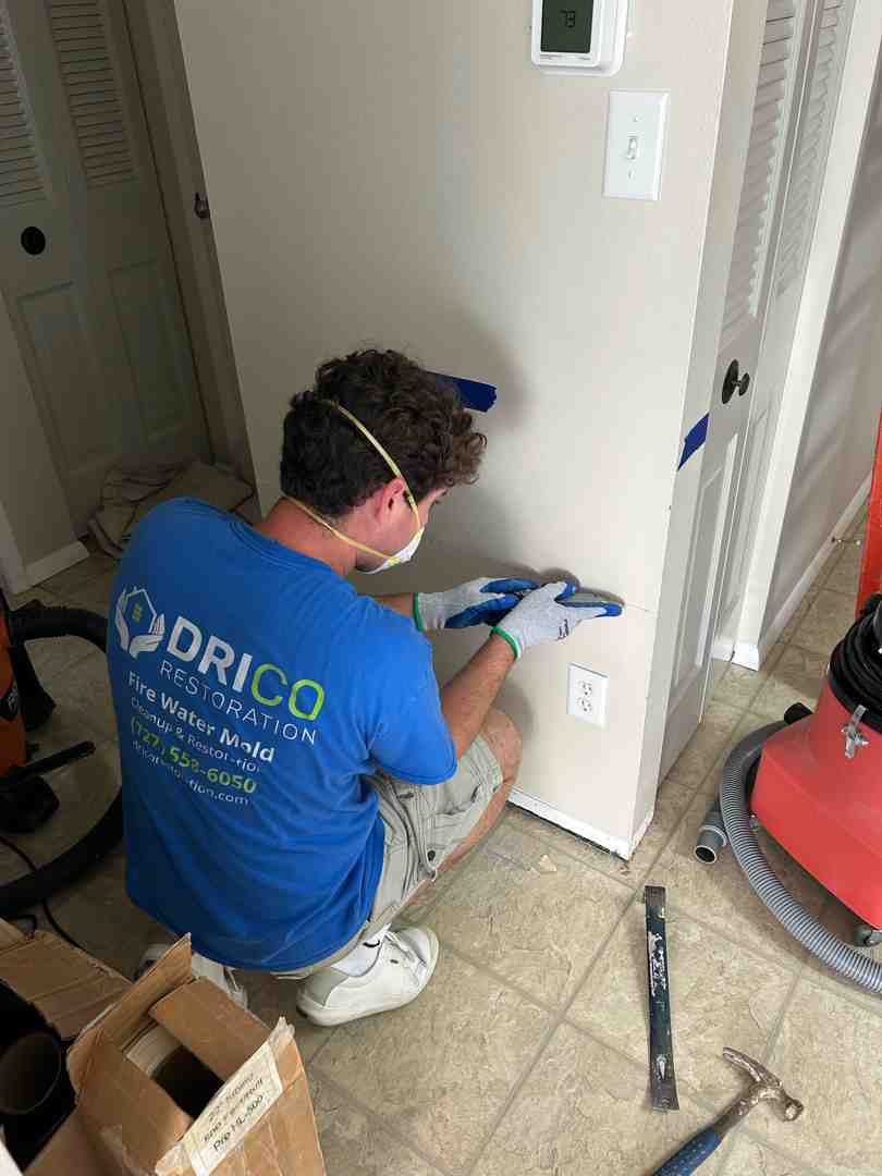 A Man Dressed In A Blue Shirt Is Engaged In Work On A Wall, Demonstrating A Hands-On Approach.