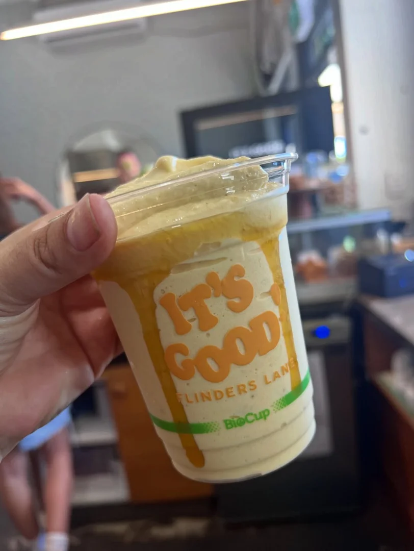 A thick, yellow mango-based smoothie in a takeaway cup, a refreshing choice for those seeking healthy morning smoothies.
