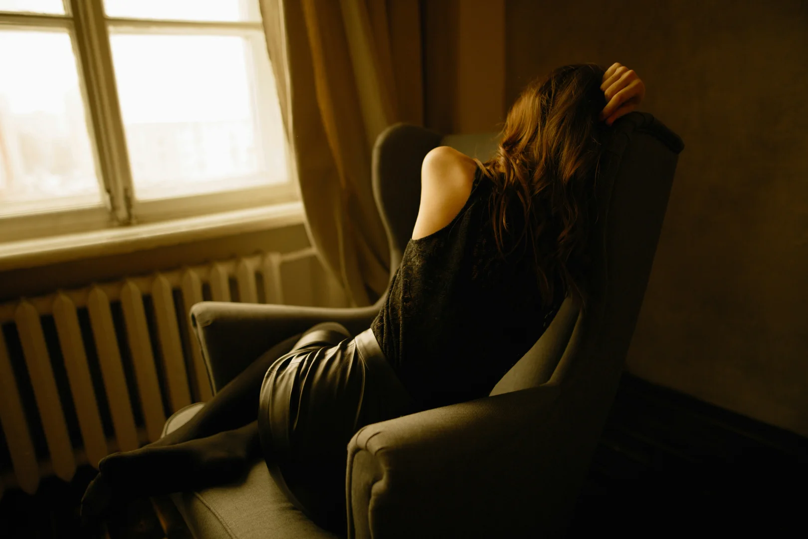 person sitting in a warm sunlit therapy room in Barcelona looking contemplative person sitting in a warm sunlit therapy room in Barcelona looking contemplative
