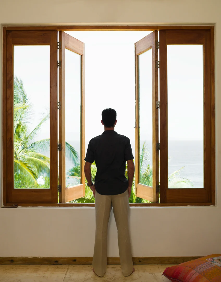 A person looking out a window at a new city, appearing thoughtful - Therapy for life transitions