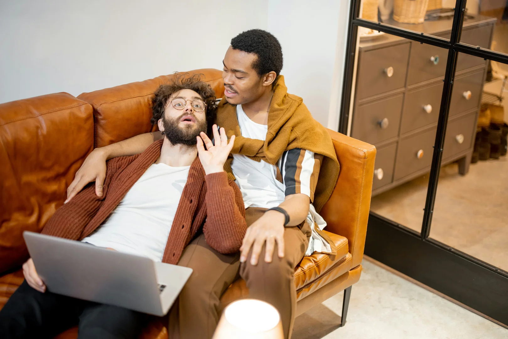 A couple holding each other, listening with expressions of earnestness and deep connection, sitting close on a couch. - marital therapy exercises