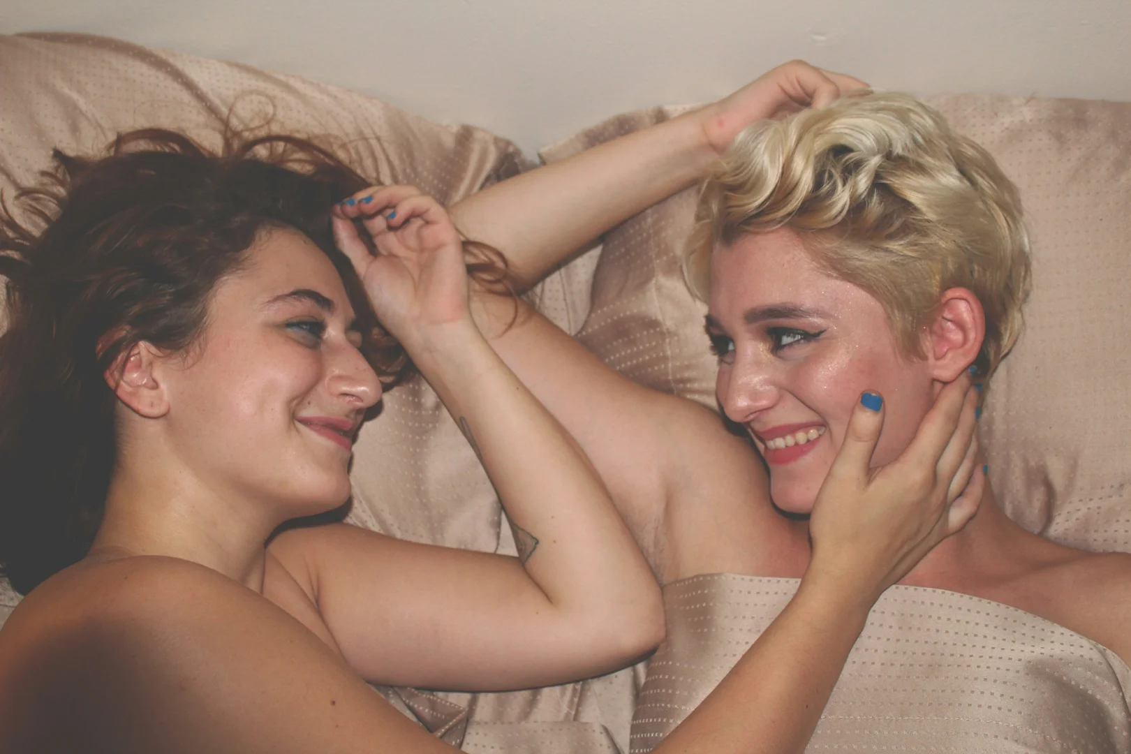 A couple sitting in bed, looking into each other's eyes, conveying a sense of quiet connection and understanding. - couples intimacy therapy near me