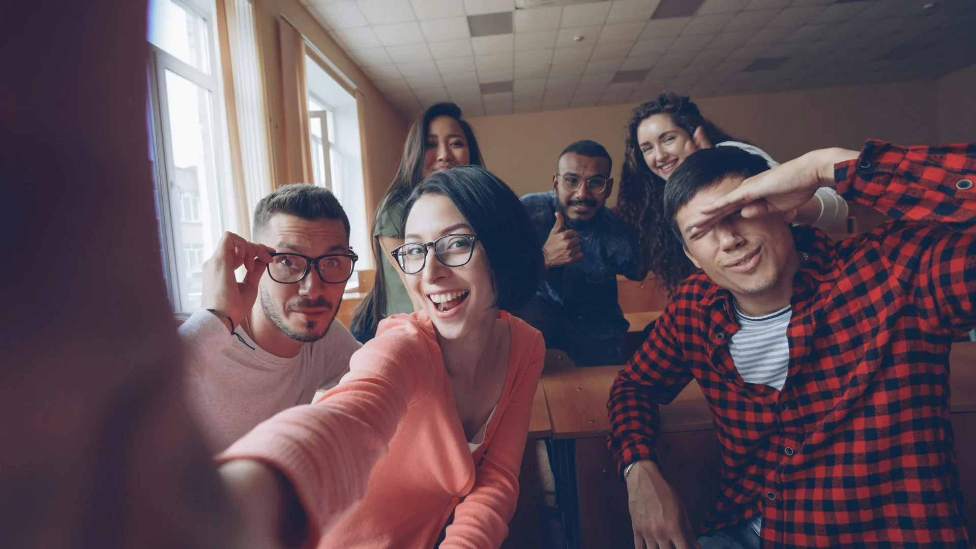 A diverse group of friends taking a selfie in a classroom. - 2 important aspects of biculturalism A diverse group of friends taking a selfie in a classroom. - 2 important aspects of biculturalism