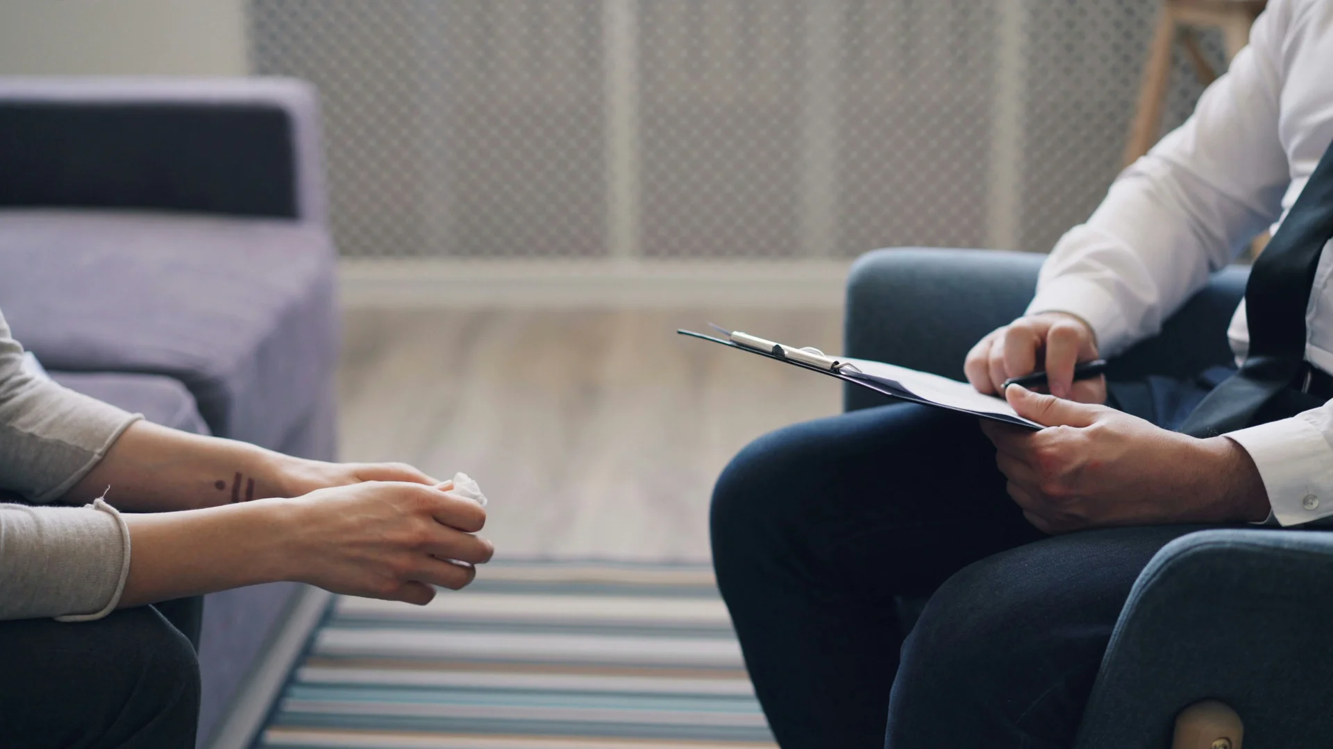Two people sitting opposite each other, one looking frustrated - EMDR Therapy Spain