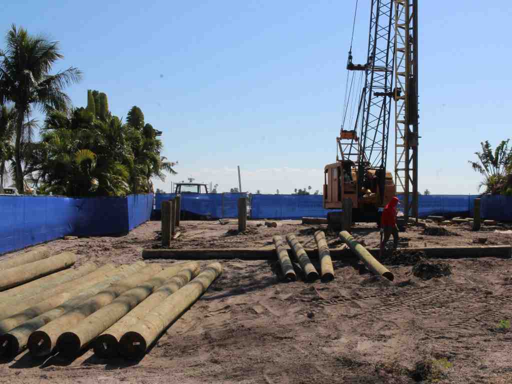 Client viewing their custom home project's progress on a tablet using a digital project management dashboard - coastal construction