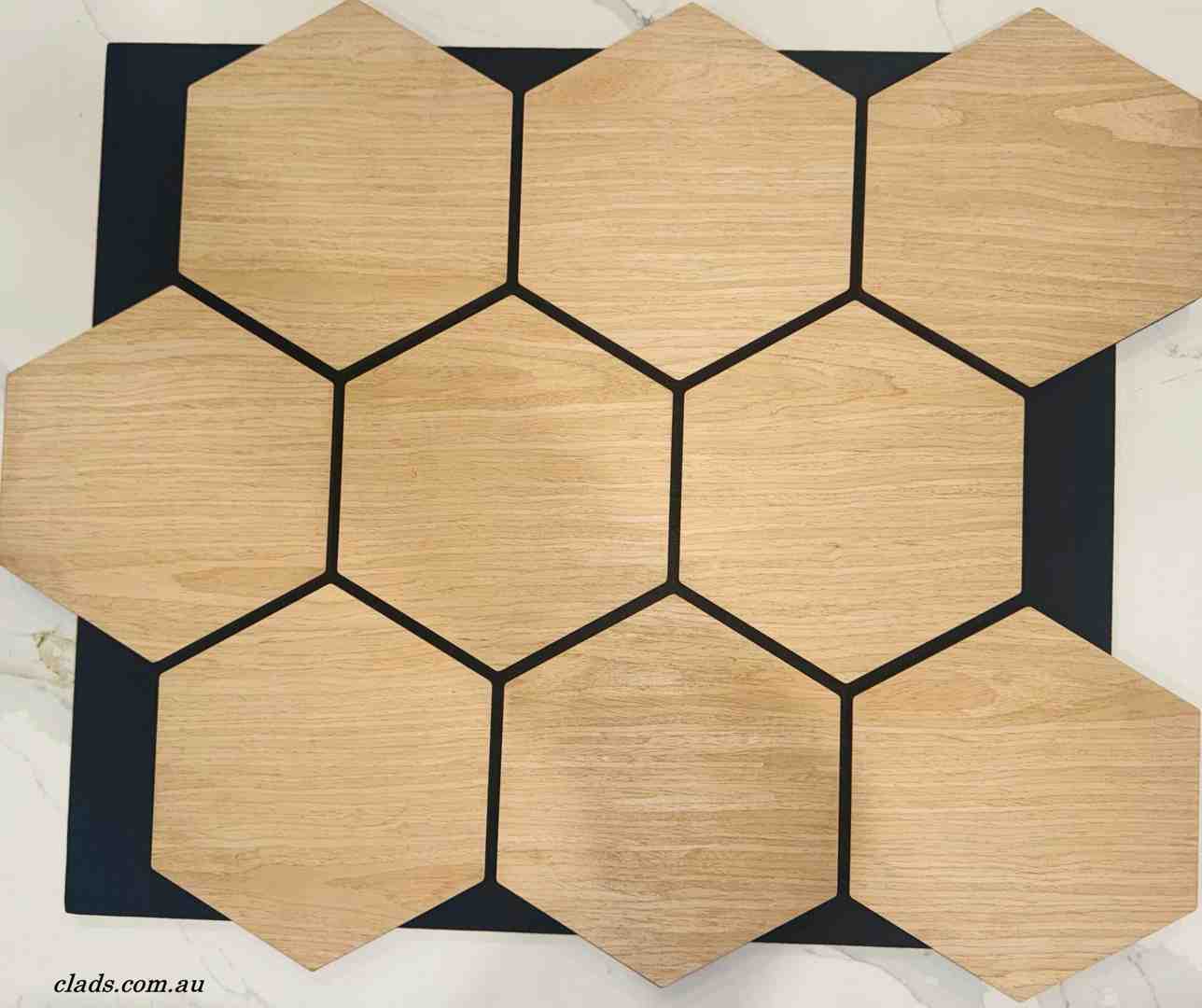 Hexagonal wood grain acoustic panels for soundproofing arranged in a geometric honeycomb pattern.