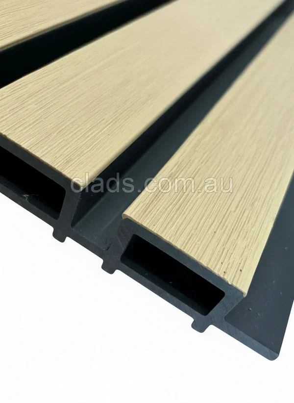 Close-up of composite wall panels with a realistic timber grain finish and a durable black grooved backing system.