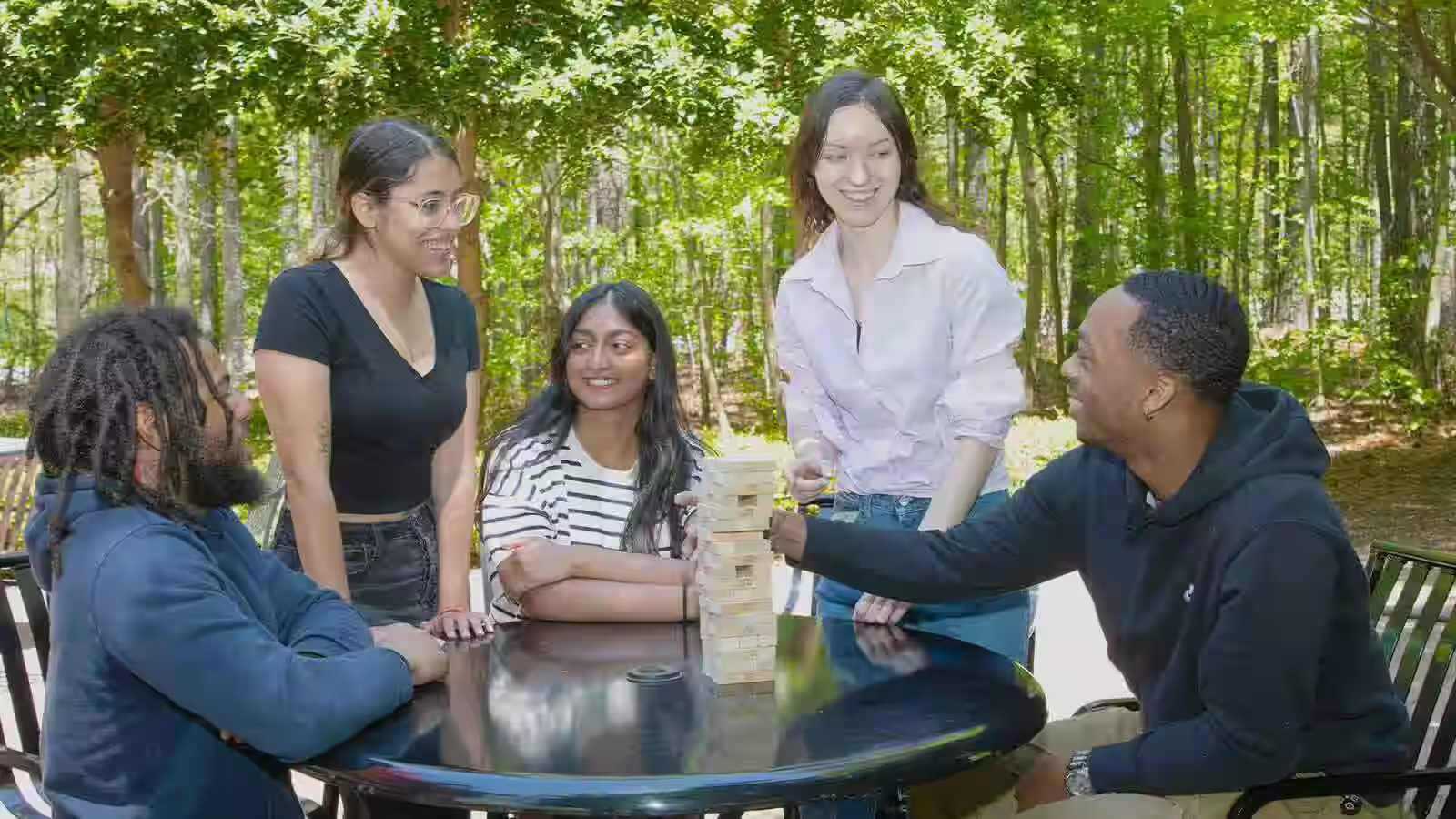 A diverse group of people sitting in a circle outdoors in a sunny Richmond park, engaged in conversation and supporting each other. - drug rehab centers in richmond va