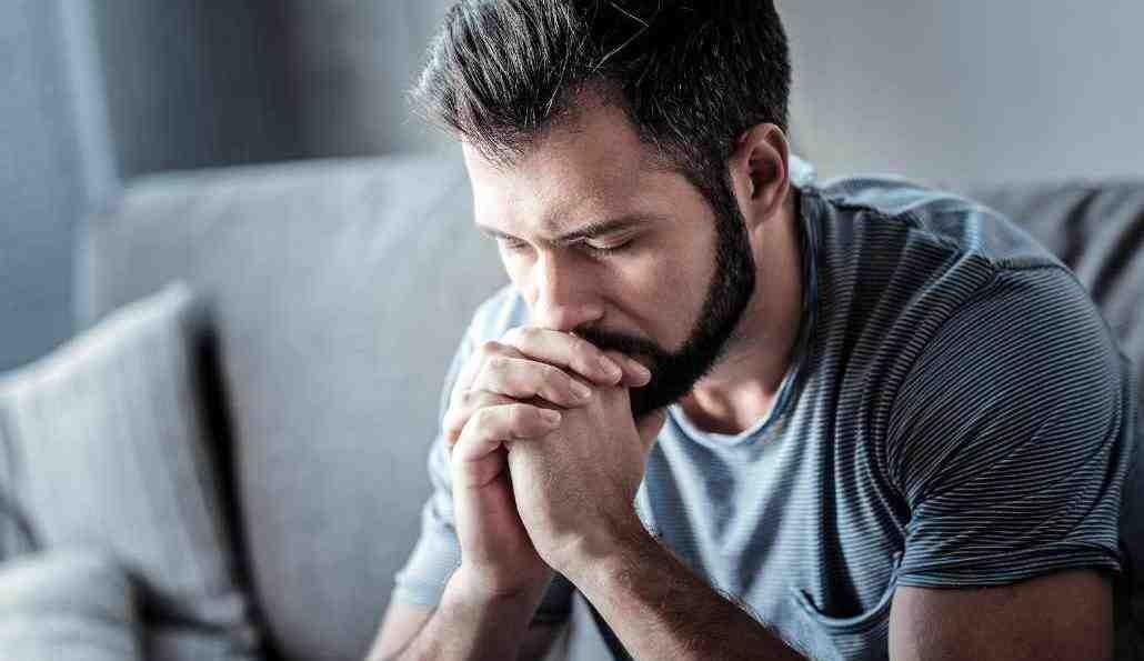 A person sitting alone at a family gathering, looking withdrawn and isolated, subtly indicating signs of addiction. - addiction and rehab hotlines/california numbers