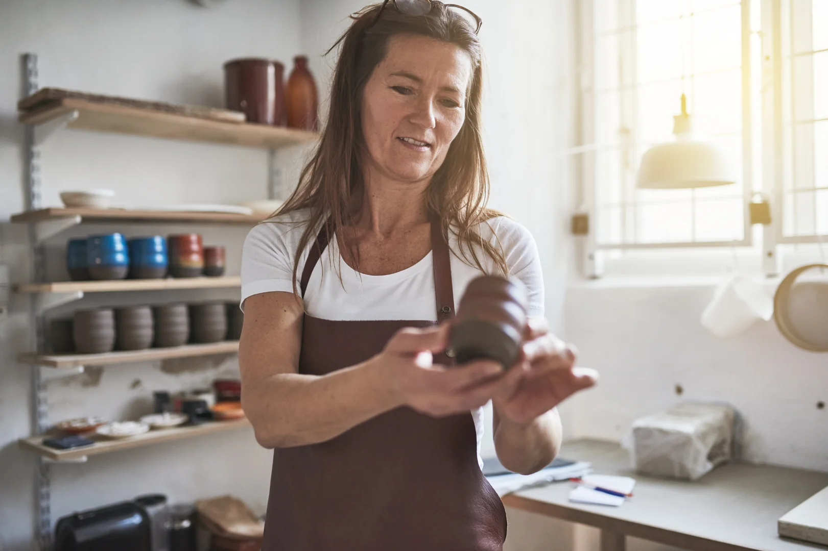 person sitting on white chair looking thoughtfully at a laptop screen - how to choose right therapist