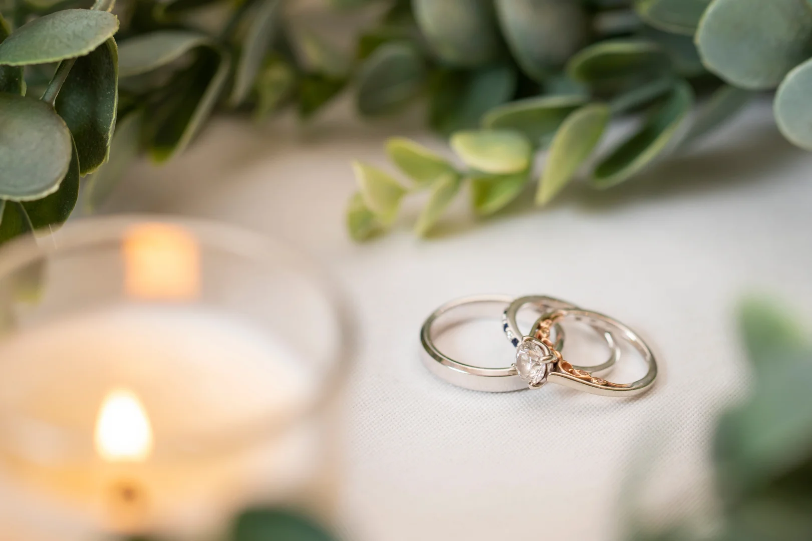 wedding ring resting together on a natural white wood table