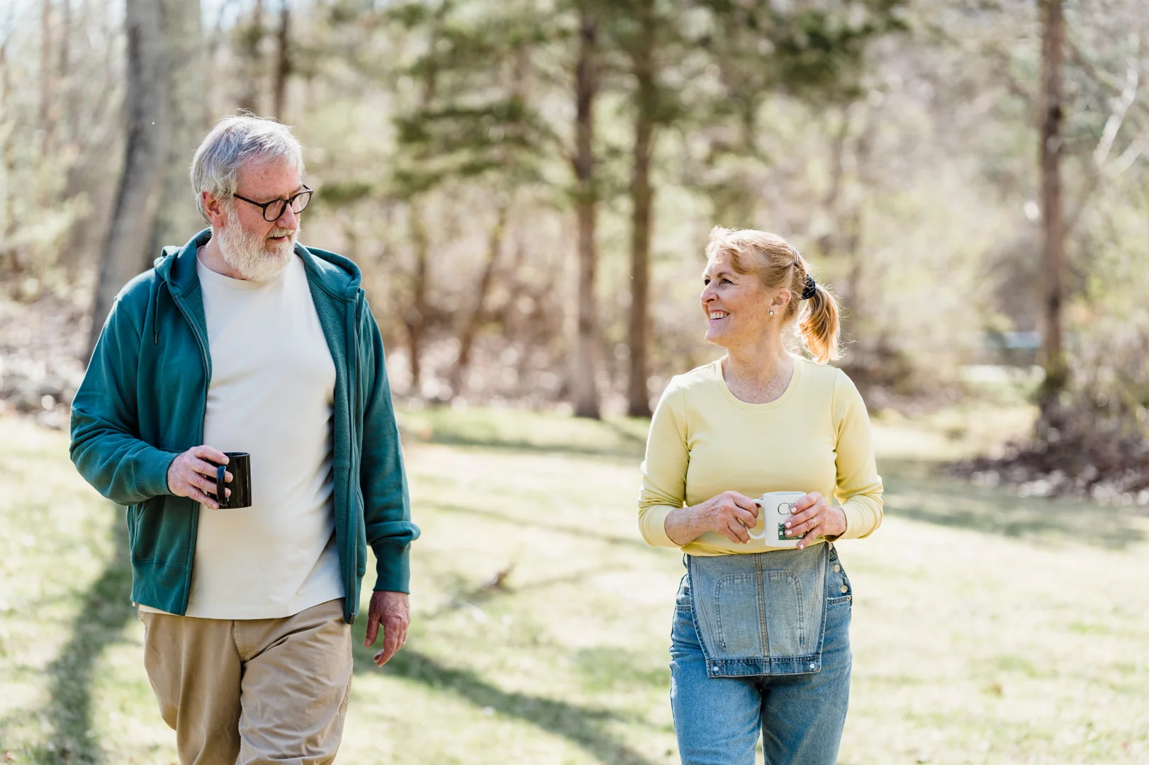 a heterosexual couple in their 50s walking in the morning in a natural trail-smiling- communication in relationships a heterosexual couple in their 50s walking in the morning in a natural trail-smiling- communication in relationships