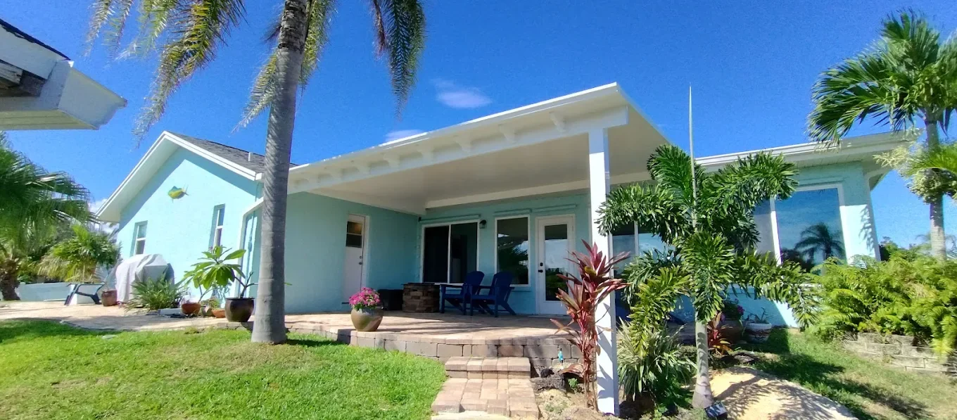 user-inserted Light blue house exterior with insulated aluminum roof panels providing shade.