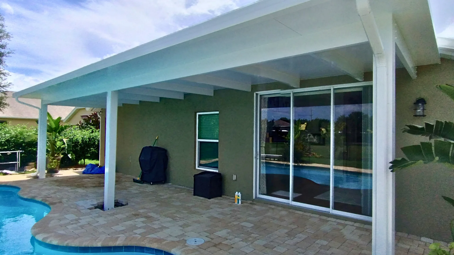 user-inserted Insulated aluminum roof panels create a cool patio cover over a pool area.