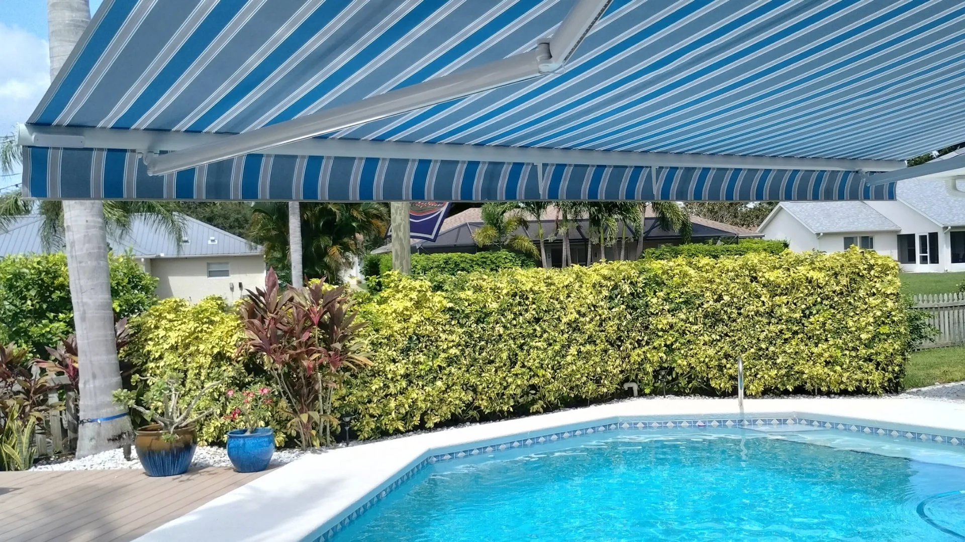 Motorized retractable awning providing shade over an outdoor living area Motorized retractable awning providing shade over an outdoor living area